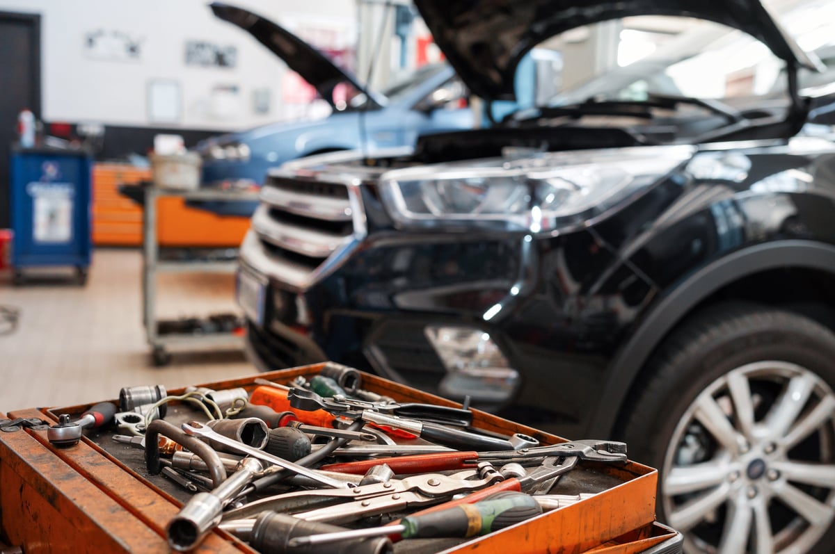Mechanical tools laid out beside an open engine bay
