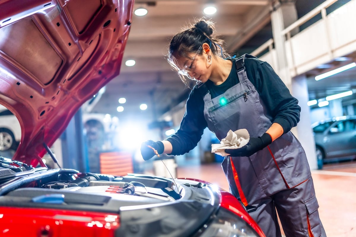 Mechanic checking the oil level of a car engine