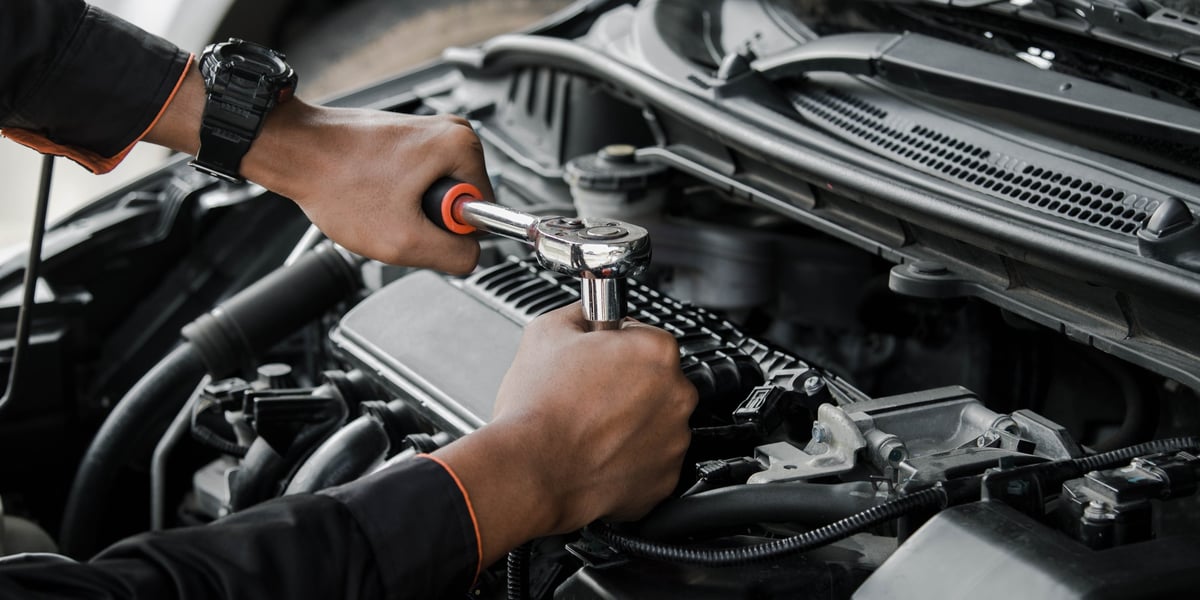 Mobile mechanic repairing a car at a customer's home
